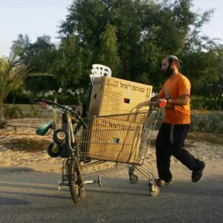 On August 21, 2005, a Jewish settler carts away his belongings before Israeli soldiers arrived to evacuate the Jewish settlement of Katif in the Gaza Strip.