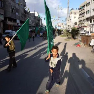 A Palestinian boy marches with a Hamas flag after the Palestinian election in the Gaza Strip on January 26, 2006. 